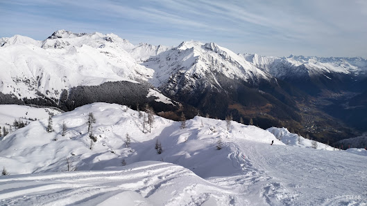A charming chalet nestled in Colere Bergamo Italy with skiers enjoying winter sports amidst the breathtaking mountain backdrop of the ski resort.