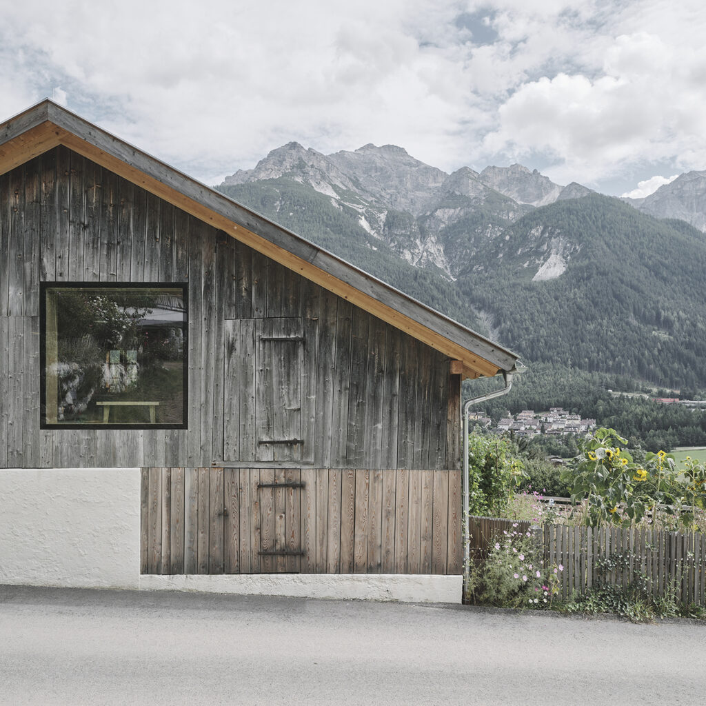 A mountain hut resembling a chalet tucked neatly amidst the snow-blanketed landscape in Colere Bergamo Italy. A sprawling mountain forms a captivating backdrop to this serene winter scene.