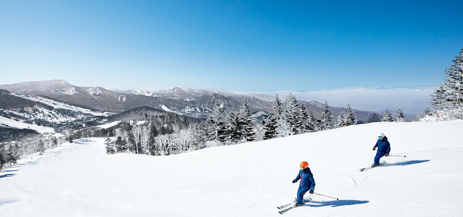 Yakebitaiyama in Japan - two people skiing down a snowy mountain.