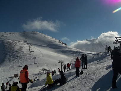 A scenic view of the Métabief ski resort in Bourgogne-Franche-Comté France featuring a chalet with skiers enjoying winter sports amidst a frosty landscape.