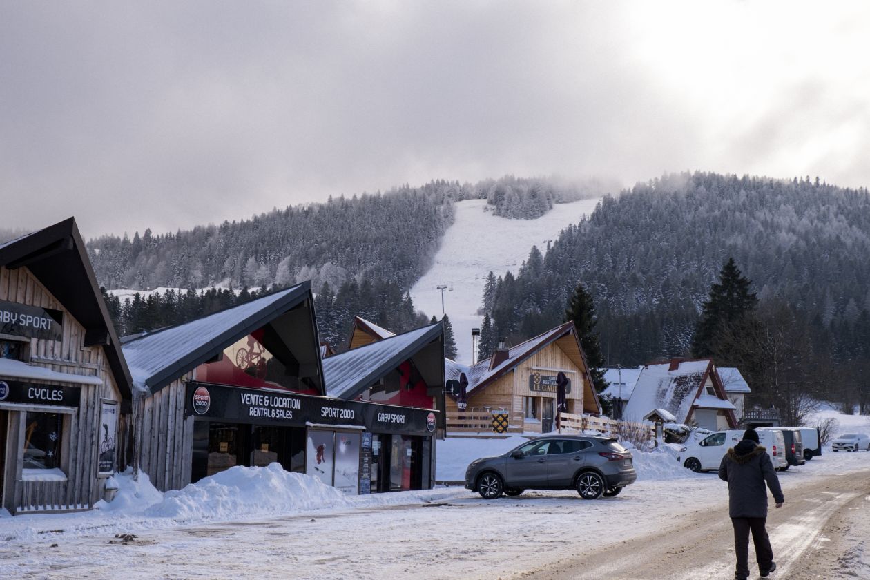 Métabief in France - a person walking down a snow covered street.
