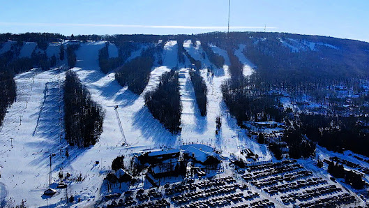 A ski resort in Dombai Caucasus featuring a ski lift ascending towards snow-covered slopes. The scene embodies the bustling activity commonly seen at a winter sports centre.
