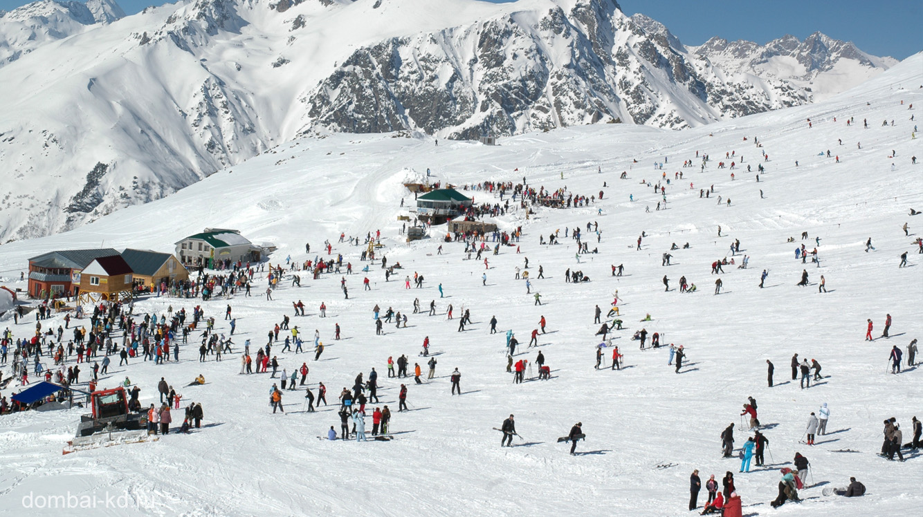 Dombai in Russia - a large group of people skiing down a mountain.