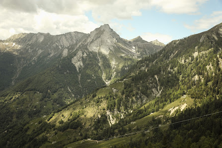 A picturesque view of Moléson in Switzerland showcasing a majestic mountain with a cozy challet nestled near its base. A mountain bike is visible suggesting an active outdoor lifestyle. A potential ski resort and mountain hut are subtly noted in the backg