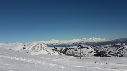 A chalet at Monte Magnola ski resort in Ovindoli, Italy during winter. Skiers enjoy the snowy mountain slopes as part of a vibrant winter sports scene.