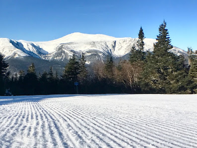 A skier enjoying winter sports at Wildcat Mountain ski resort in Gorham New Hampshire USA. The image showcases snow-covered slopes and the magnificent mountain in the background.