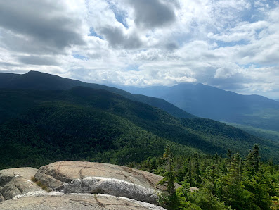 View of a scenic mountain on a sunny day in Wildcat Mountain, Gorham, New Hampshire, USA, with a glimpse of a challet nearby.