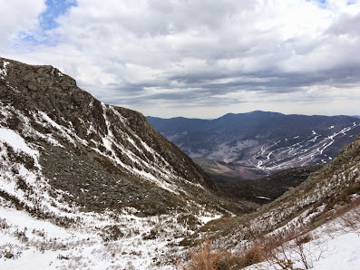 Stunning view of Wildcat Mountain in Gorham, New Hampshire, capturing a vibrant winter sports scene amidst breathtaking winter scenery. A quaint chalet adds charm to the snow-covered landscape.