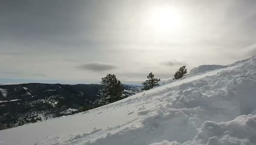 A skier navigating down a snowy slope at Beaver Mountain, Garden City, Utah. The scene captures the essence of winter sports against the backdrop of a stunning mountain landscape.