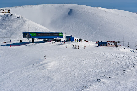 Snapshot of Big Wood ski resort in Kirovsk, Russia, showcasing a vibrant winter sports scene. Snow-covered slopes are dotted with skiers, promoting the aura of an active winter sports centre.