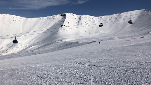 Skier enjoying a run at the charming ski resort in Big Wood, Kirovsk, Russia, surrounded by snow-covered slopes and chalets.
