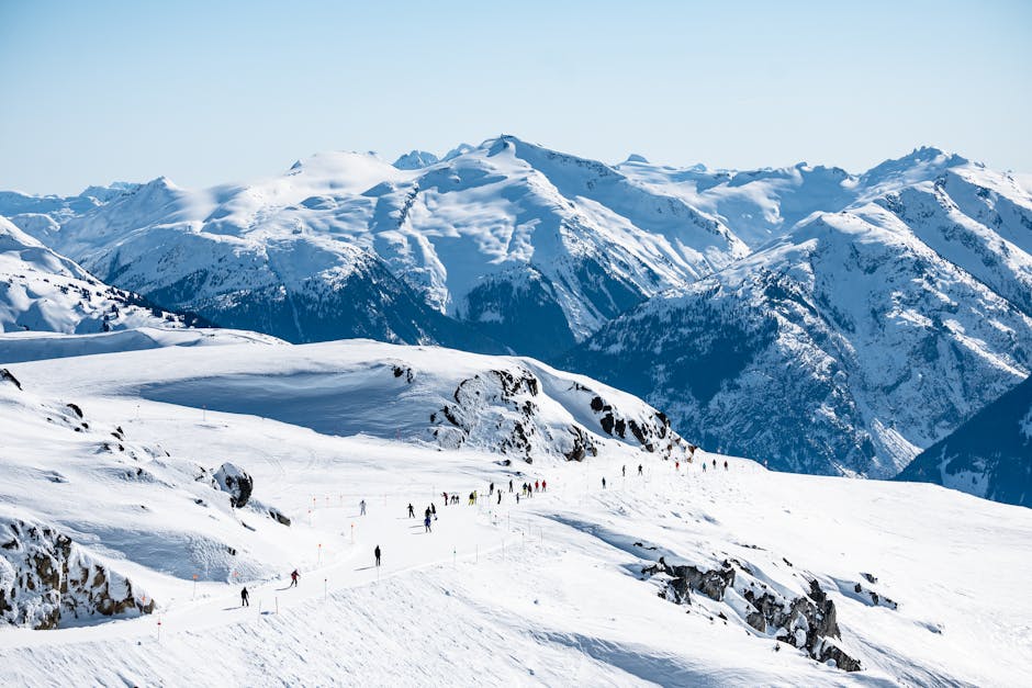 Whistler Blackcomb in Canada - a group of people skiing down a snow covered mountain.