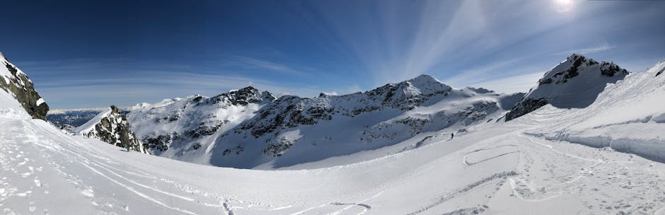 Whistler Blackcomb in Canada - a snowboarder is going down a snowy slope.