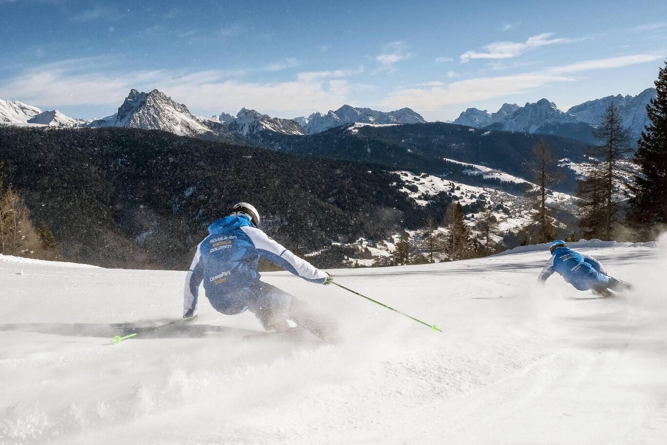 Padola Val Comelico in Italy - two people skiing down a snowy slope in the mountains.