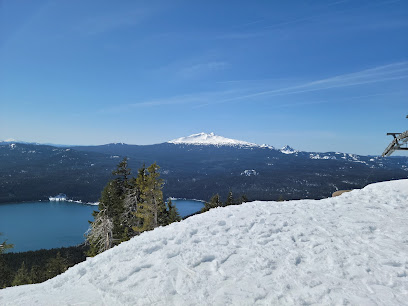 A picturesque view at Willamette Pass Resort in Oregon USA with a snow-covered mountain and slopes where a skier is enjoying winter sports.