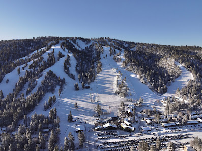 View of Snow Summit a popular ski resort in Big Bear Lake California showcasing a vibrant winter sports scene with a ski lift. A cozy chalet can also be spotted adding charm to the snowy landscape.