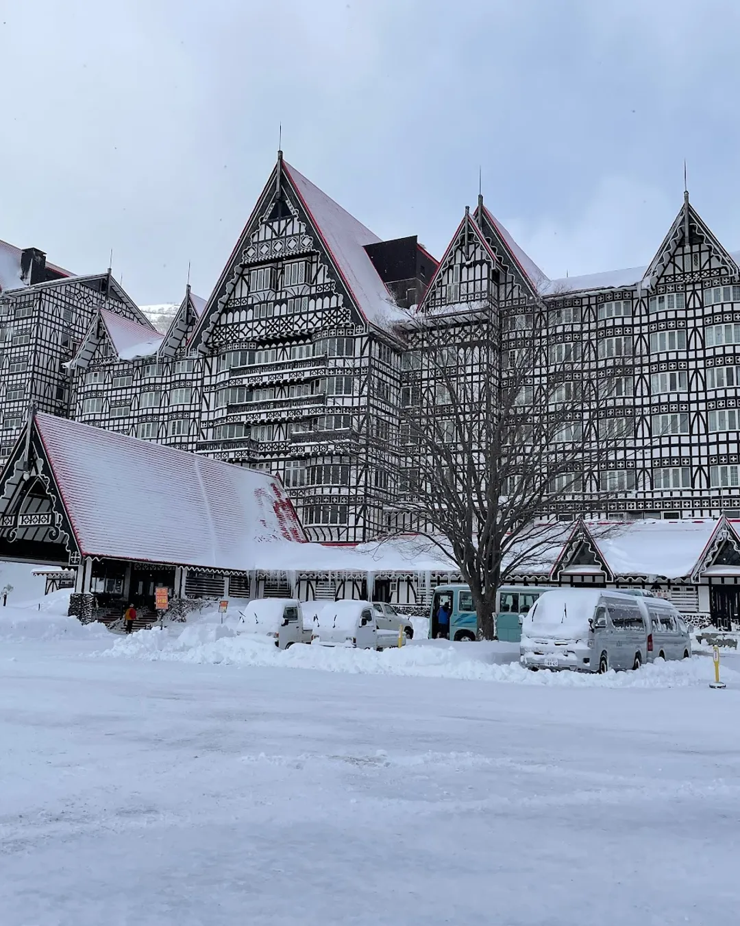 Hakuba Cortina in Japan: a large building with a lot of snow on the ground.