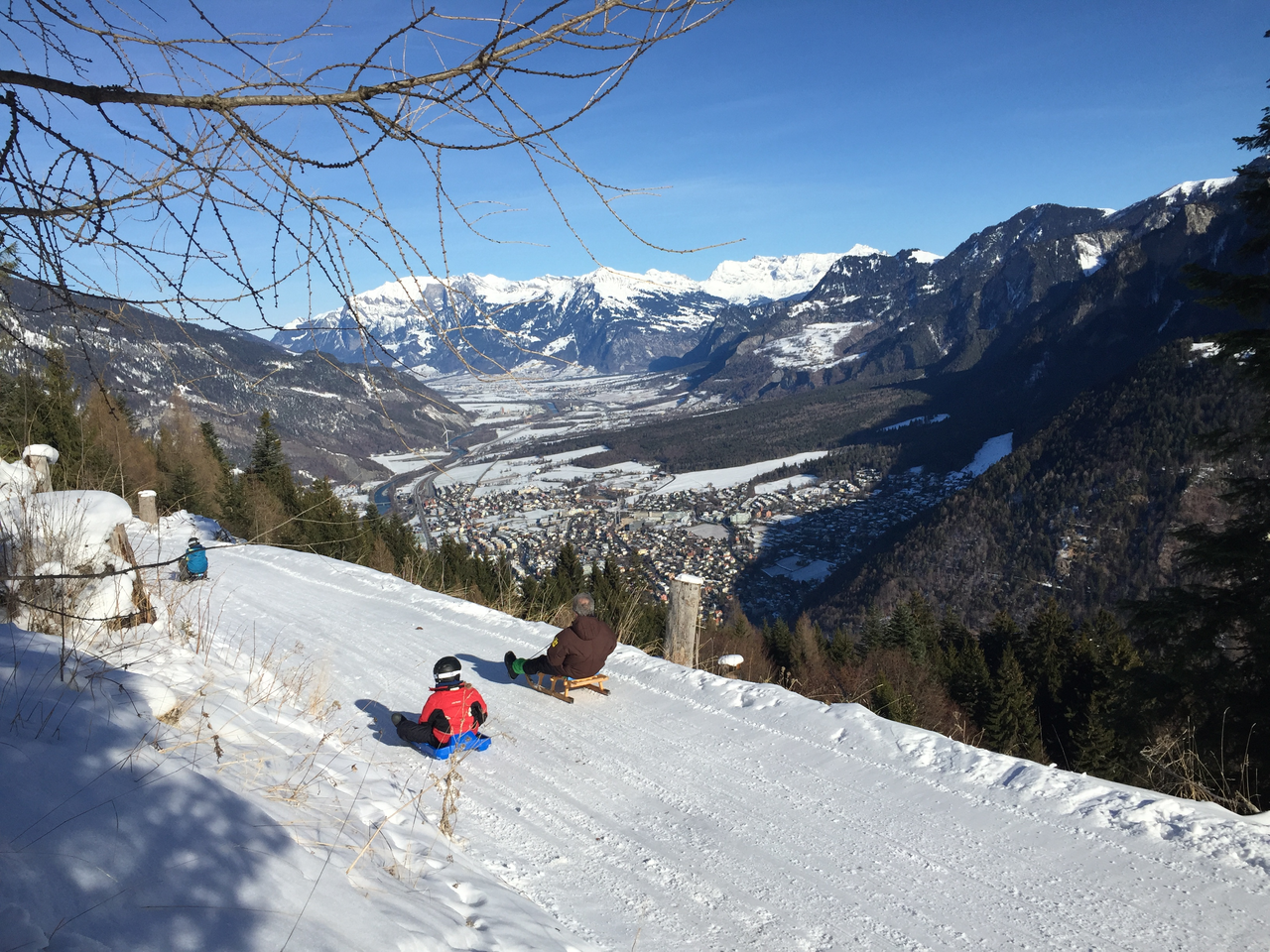 Brambrüesch - Chur Bergbahnen in Switzerland - a man riding a snowboard down a snow covered slope.