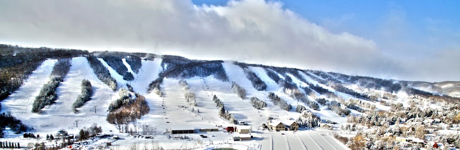 Ski enthusiasts enjoying winter sports at Craigleith Ski Club in Southern Ontario, Canada, featuring snow-covered slopes set against the picturesque backdrop of the Blue Mountains.