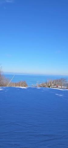 Winter sports enthusiasts enjoying a day at Craigleith Ski Club in Southern Ontario, Canada. Beautiful winter scenery includes pristine snowfall and a cozy chalet.