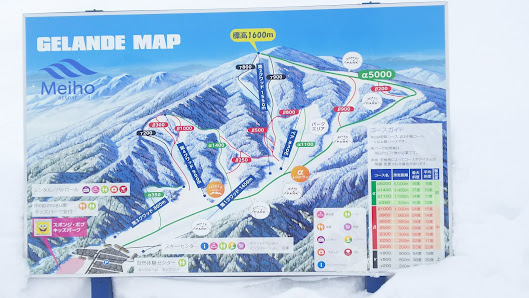 Ski resort scene in Meiho Japan featuring a chalet amidst snow-covered landscape and slopes dotted with winter sports enthusiasts. A picturesque mountain peaks in the background.