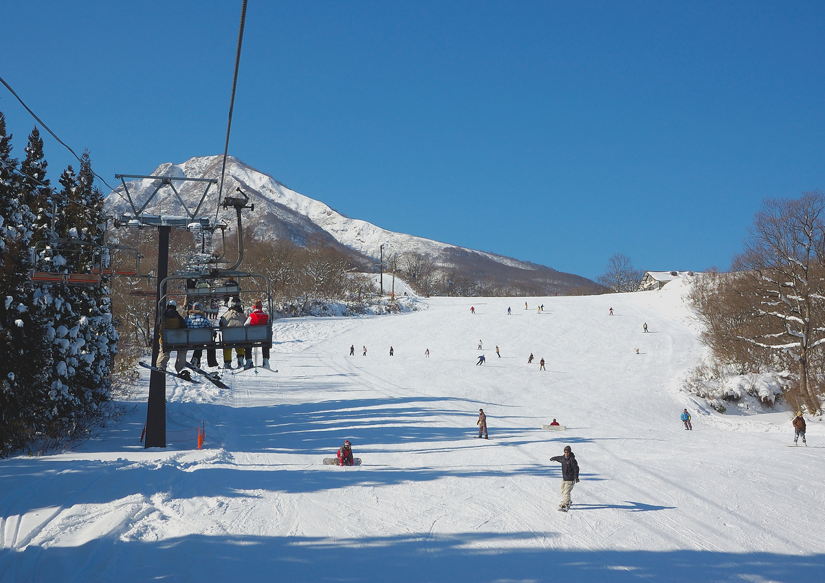 Meiho in Japan - a group of people skiing down a snowy hill.
