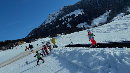 A winter sports scene in Tänndalen Northern Sweden featuring a sports centre and a chalet amidst a bustling ski resort with families enjoying skiing.