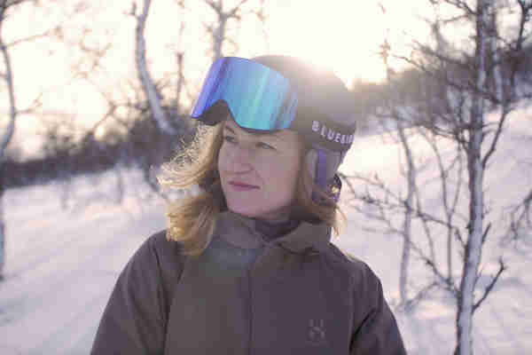 A skier and a snowboarder enjoying winter sports at Tänndalen in Northern Sweden, surrounded by a serene snowy landscape.