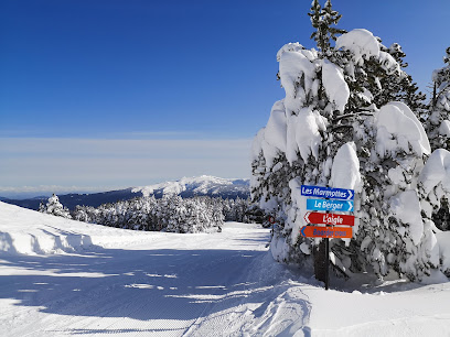 Winter scene at Valinouet Ski Resort in Quebec, Canada, featuring a bustling ski resort with a skier carving down the snow-packed slope, a distant ski lift, and a hint of a snowmobile in the background.