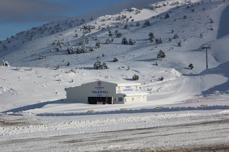View of a winter sports centre nestled amid snowy peaks in Nikfer, Tavas/Denizli, Turkey. Skiers and snowboarders can be seen enjoying the crisp winter scene.