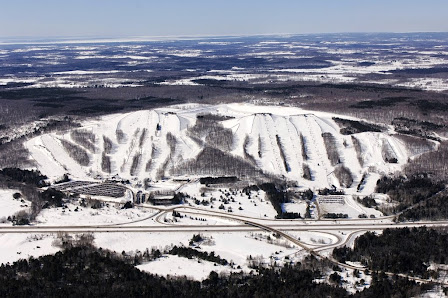 View of Mount St. Louis Moonstone ski resort in Coldwater Ontario featuring snow-covered slopes a bustling winter sports scene and a chalet.