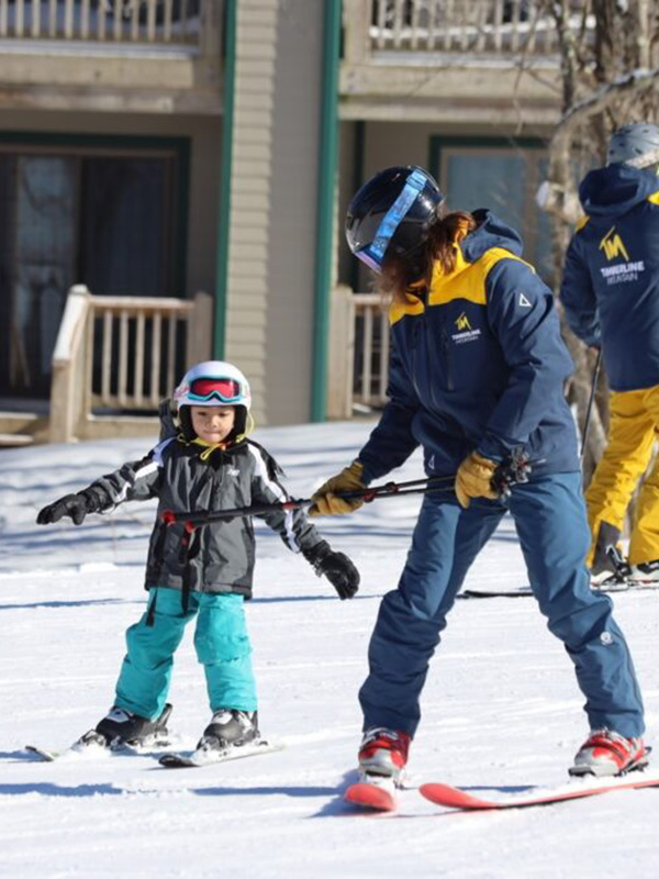 A family enjoying skiing on Timberline Mountain in Davis, West Virginia, USA, encompassing a heartwarming winter sports scene with a child learning to ski.