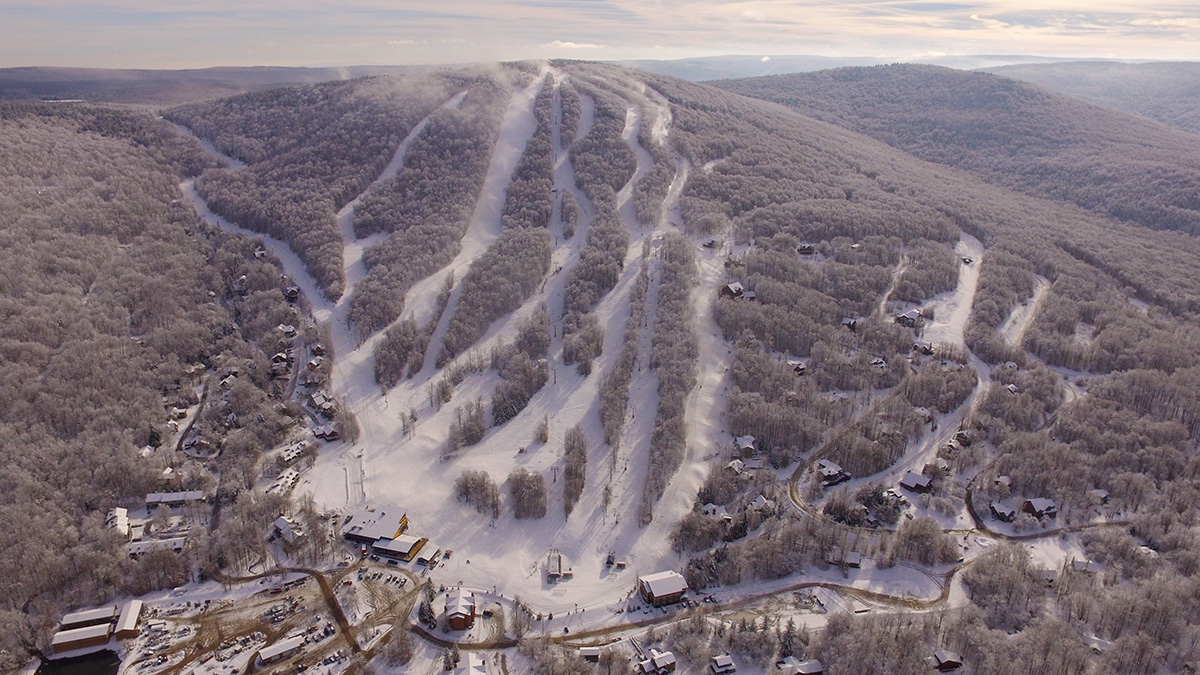 An exhilarating winter sports scene at Timberline Mountain ski resort in Davis, West Virginia, featuring snow-covered slopes, skiers in action, and a distant view of a ski lift.