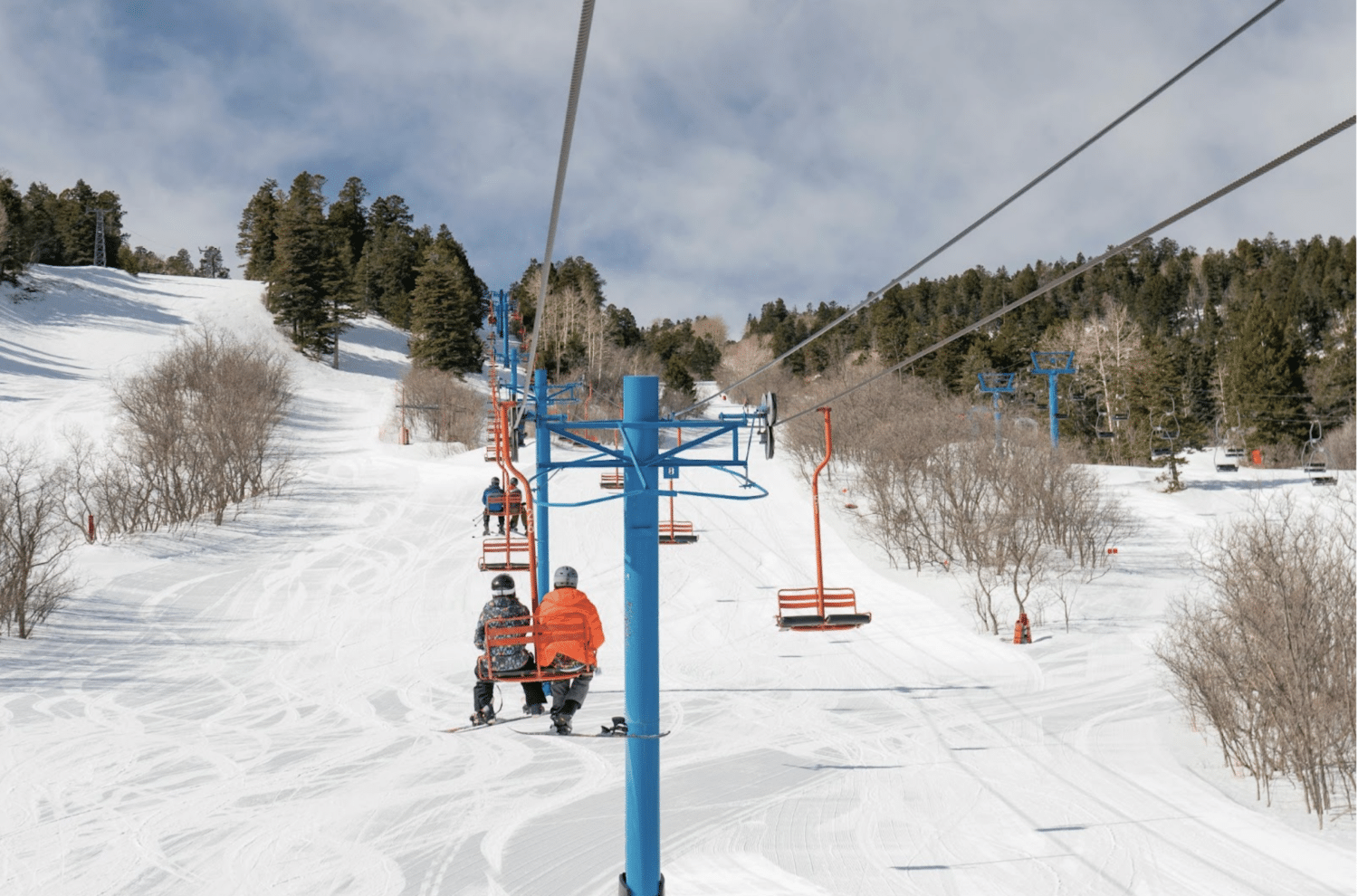 Sandia Peak in USA - a man riding a ski board down a snow covered slope.