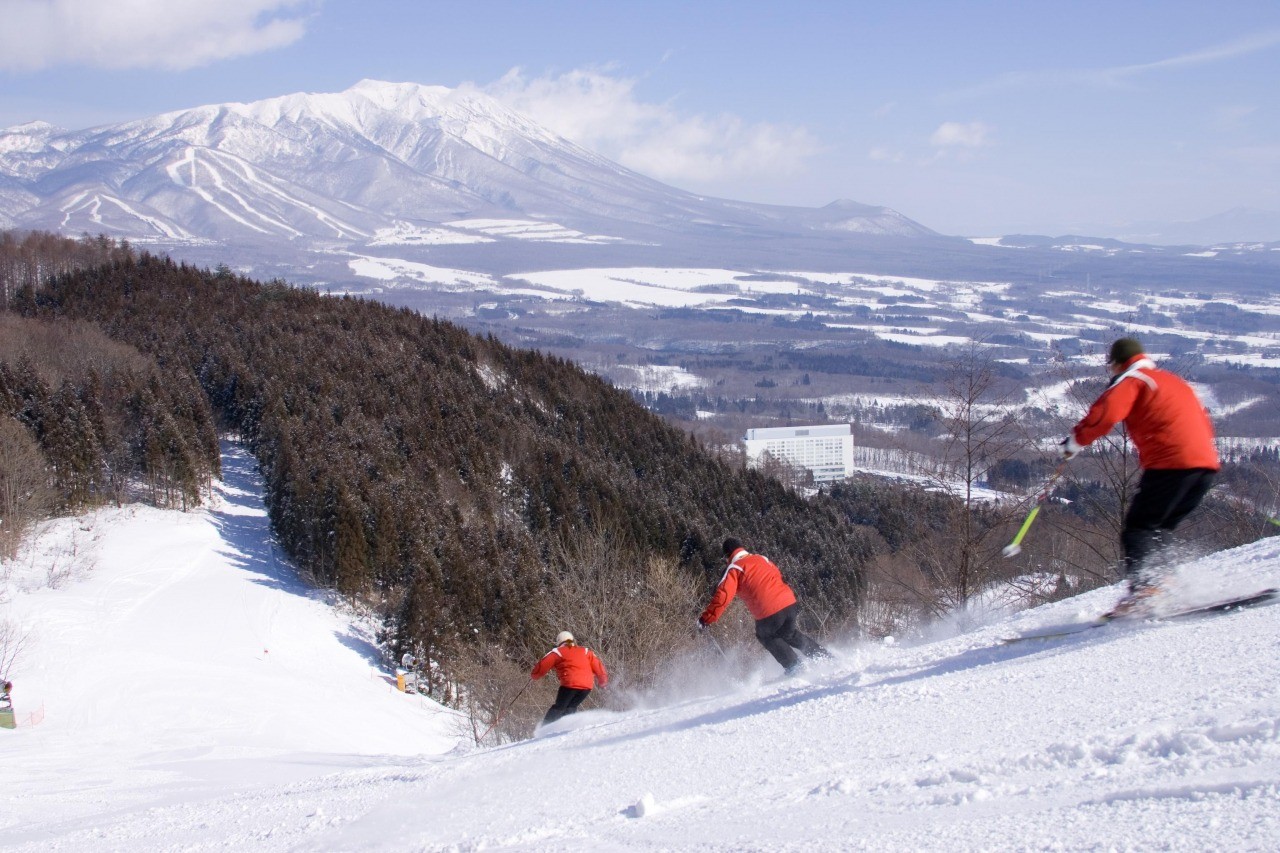 Shizukuishi in Japan - a group of people skiing down a mountain.
