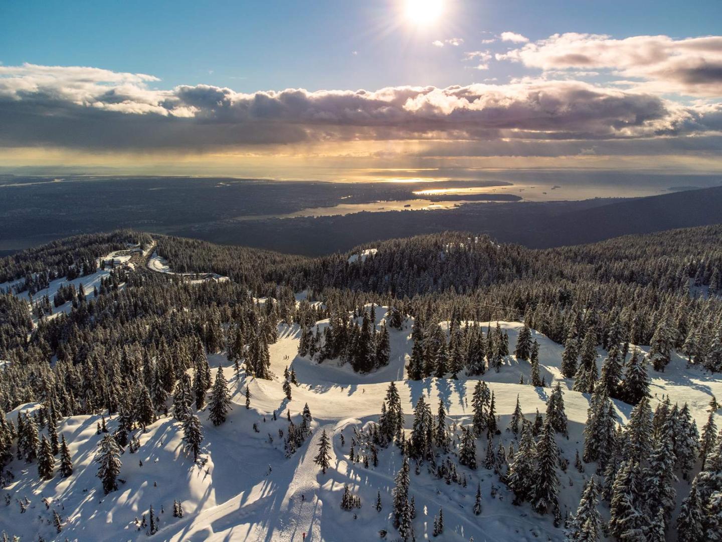Mount Seymour in Canada - the sun is shining over a snowy landscape.