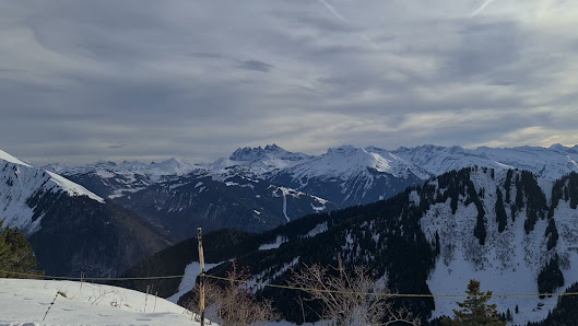 Image of a charming chalet nestled amidst the stunning winter landscape of Roc d'Enfer in Haute-Savoie, France, with the majestic mountain and a ski resort in the backdrop.