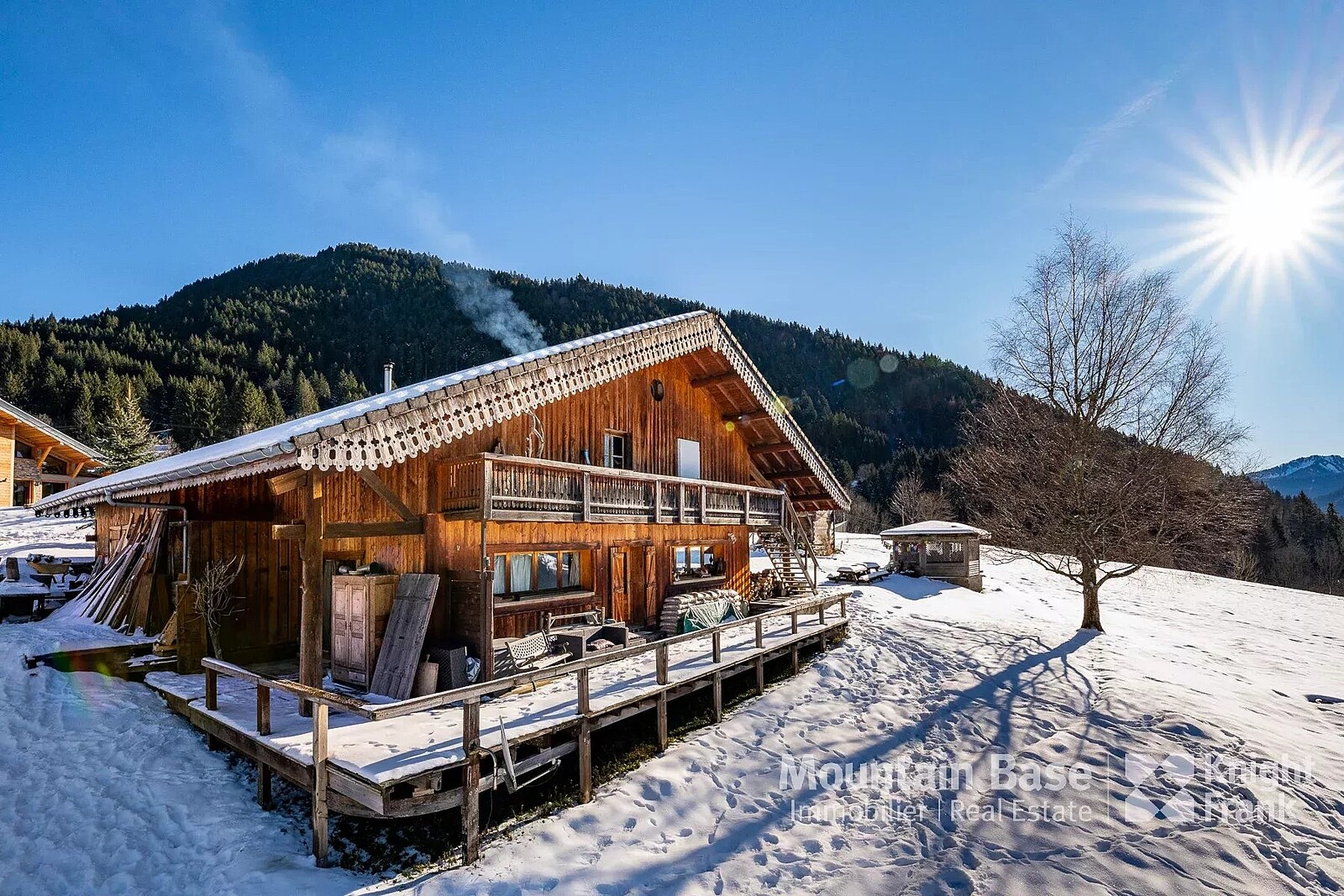 Roc d'Enfer in France - a wooden cabin in the snow with mountains behind.