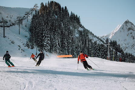 Skiers enjoying winter sports at Roc d'Enfer in Mont Blanc France. The lively scene captures the beauty of the ski resort and the exhilaration of winter activities.