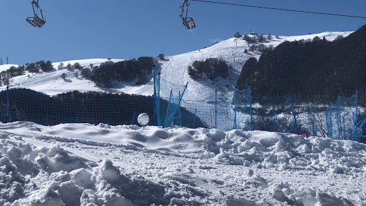 A skier enjoys a day at the Altopiano di Brentonico ski resort in Trentino Italy. On the slopes under a ski lift the lively winter sports scene is complemented by a cozy chalet nearby.