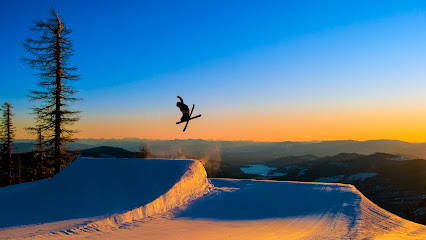 A snowboarder is gliding down a snowy slope in Altopiano di Brentonico Trentino Italy. Part of a winter sports scene with hints of other skiers in the background.