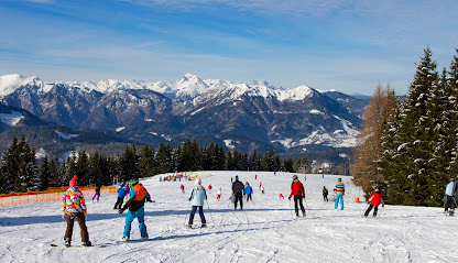 Visitors enjoy a day of winter sports at Mt. Spokane Ski & Snowboard Park with groups of people and families skiing down the snowy slopes of the resort.