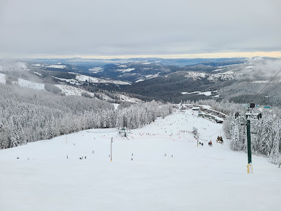 Winter scene at Mt. Spokane Ski & Snowboard Park in Mead, Washington, featuring snow-covered slopes, a ski lift and a chalet.