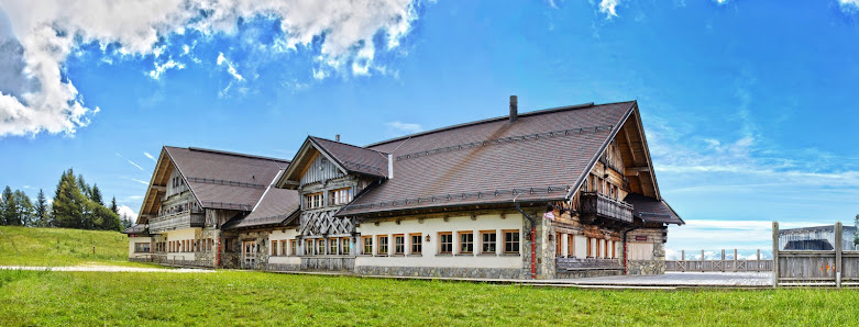 A picturesque view of Cerkno featuring a winter sports centre lodge and chalet typical to Slovenian ski resorts. Foreground full of snow-driven winter sports activities.