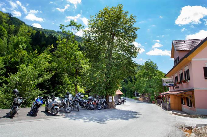 A charming chalet nestled in the heart of Cerkno Slovenia. The property lies at the base of a gentle mountain slope signaling its proximity to a ski resort. It's a sunny day perfect for outdoor activities.