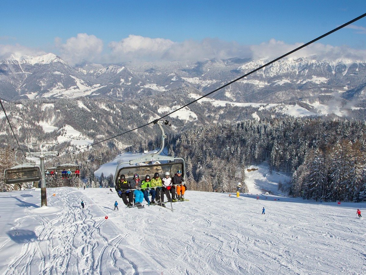Cerkno in Slovenia - a group of people riding on top of a ski slope.