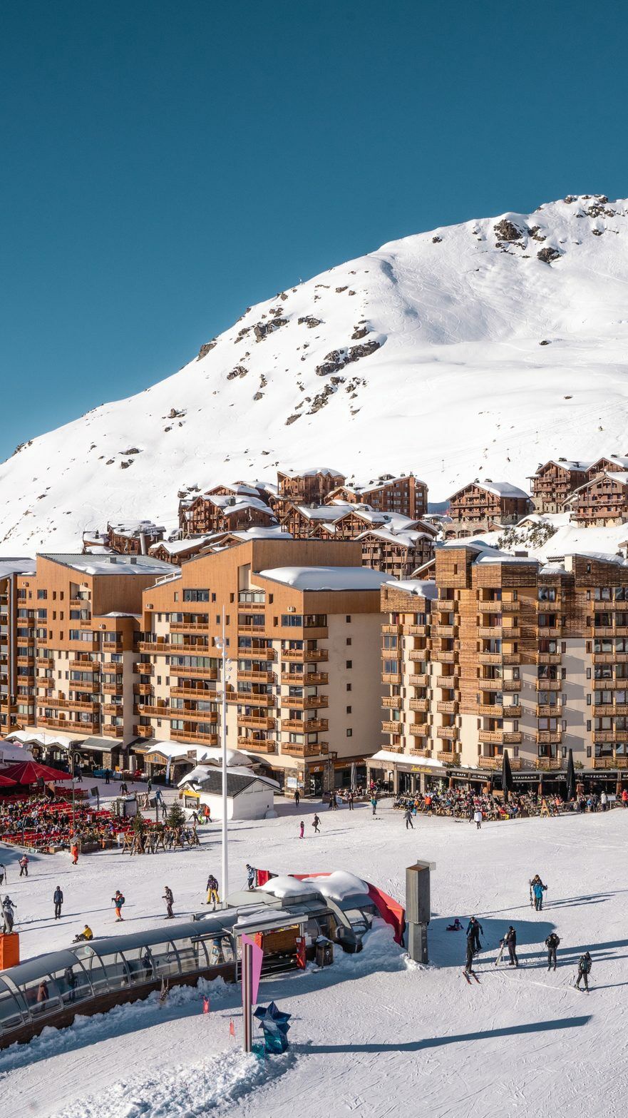 Les 3 Vallées in France - a group of people skiing down a snow covered slope.