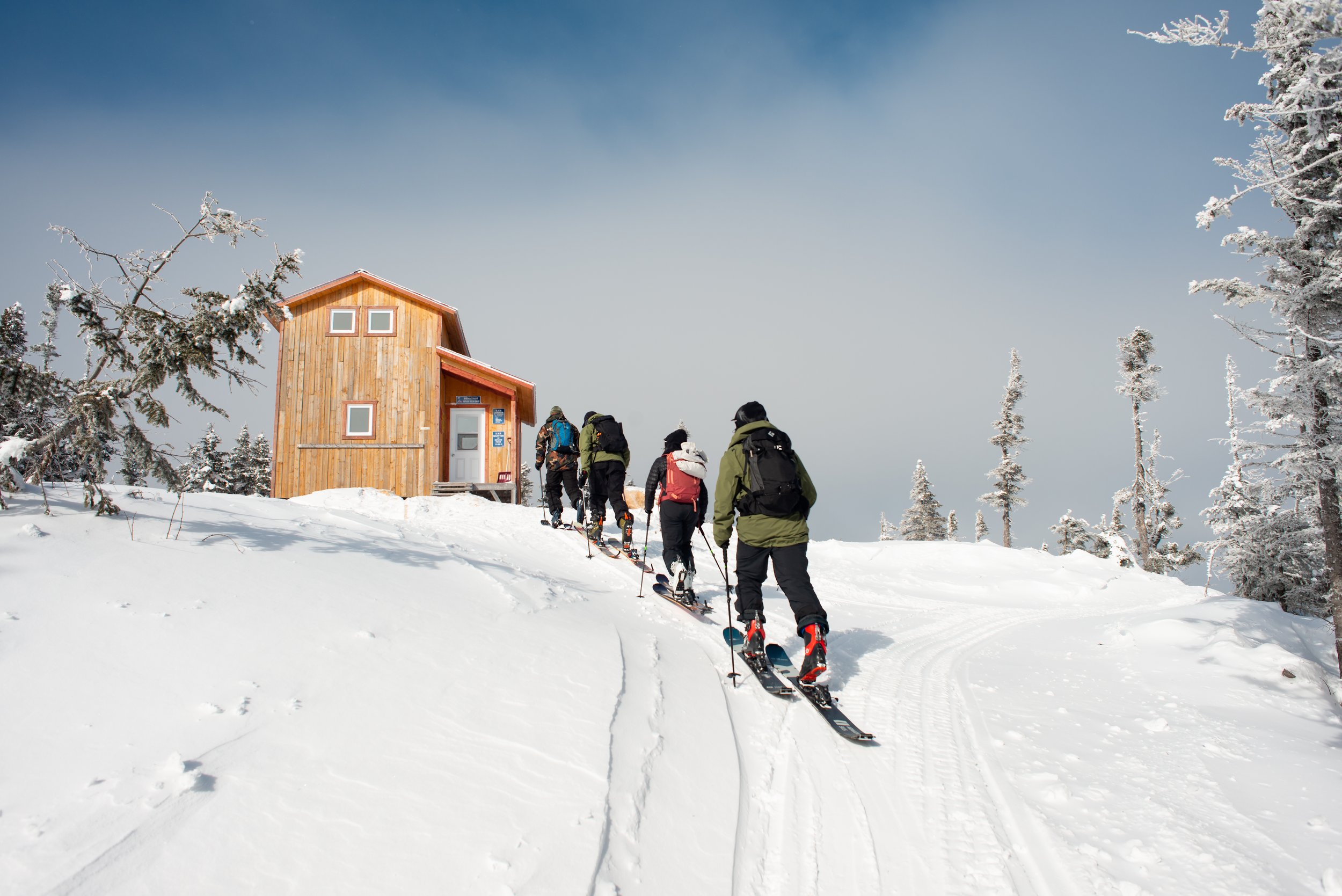 Winter sports enthusiasts enjoy a day at Mont Edouard in Quebec, Canada, filled with skiing activities. The image beautifully captures a mountain hut, ski resort, and a ski lift.