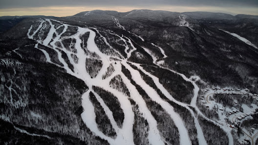 A beautiful winter scene at Mont Edouard ski resort in Quebec Canada featuring snow-covered slopes and a scenic winter sports scene.