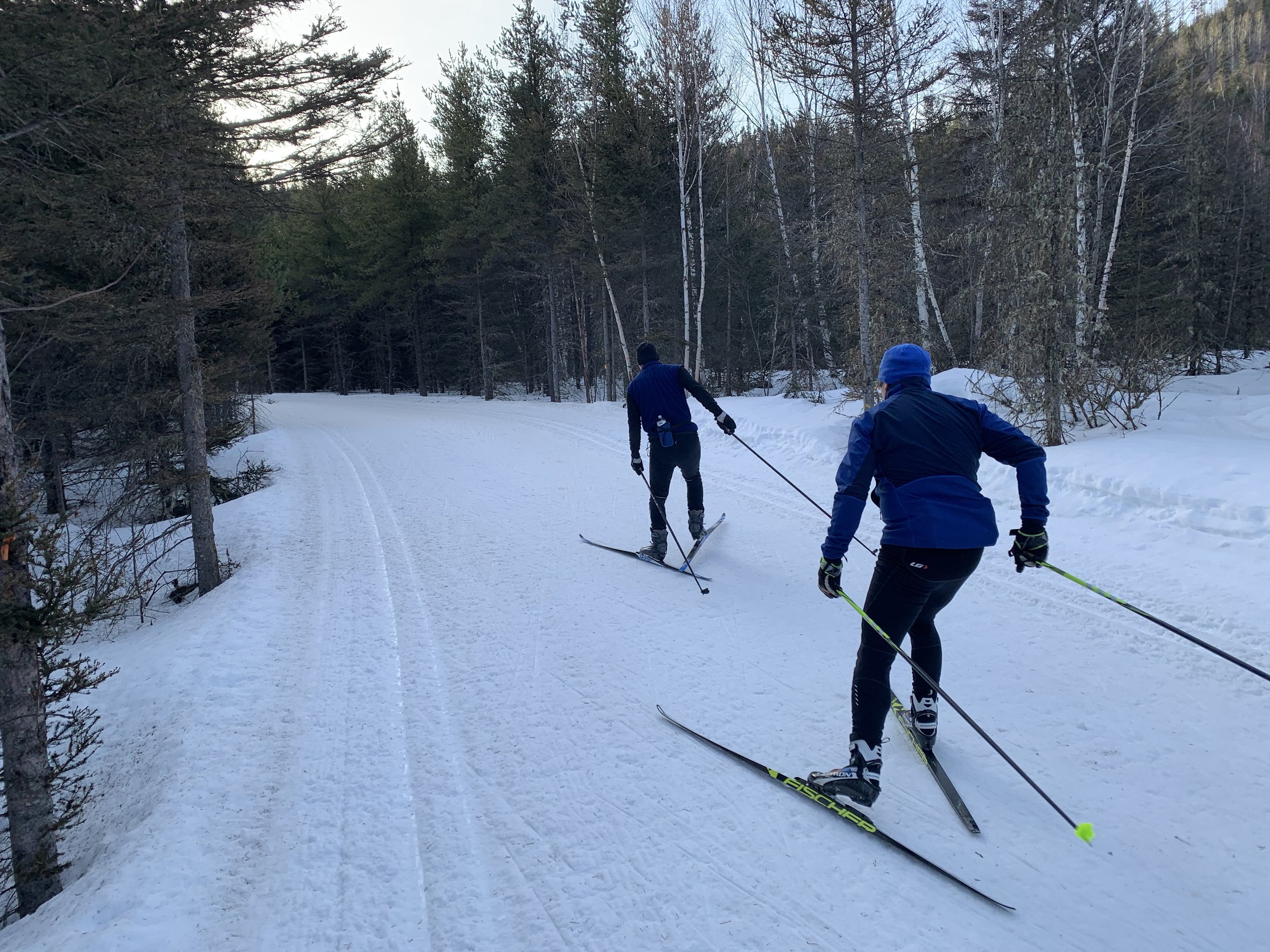 Winter sports scene at Mont Edouard in Quebec, Canada showcasing a family and other skiers enjoying their day on the slopes.